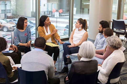 team sitting in circle and discussing